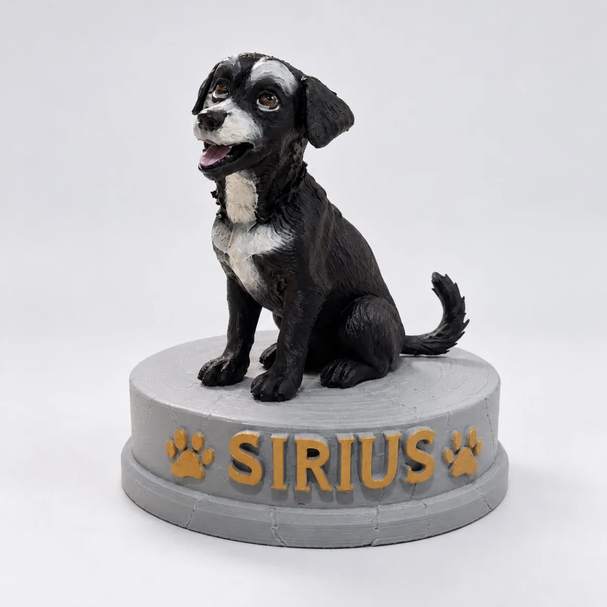 Miniatura de um cachorro preto e branco sentado sobre uma base cinza com o nome Sirius